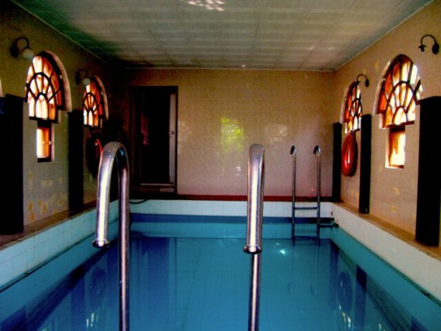 Seguimos por este recinto, de momento nadie nos ha atendido y el taxista se muestra algo incomodo buscando a alguien, pero decidimos seguir andando y viendo las instalaciones. Vemos una piscina y al fondo, aunque no se aprecie una puerta donde se accede a la sauna.